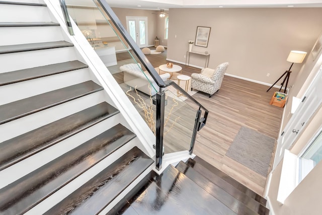 stairs featuring ceiling fan and hardwood / wood-style floors