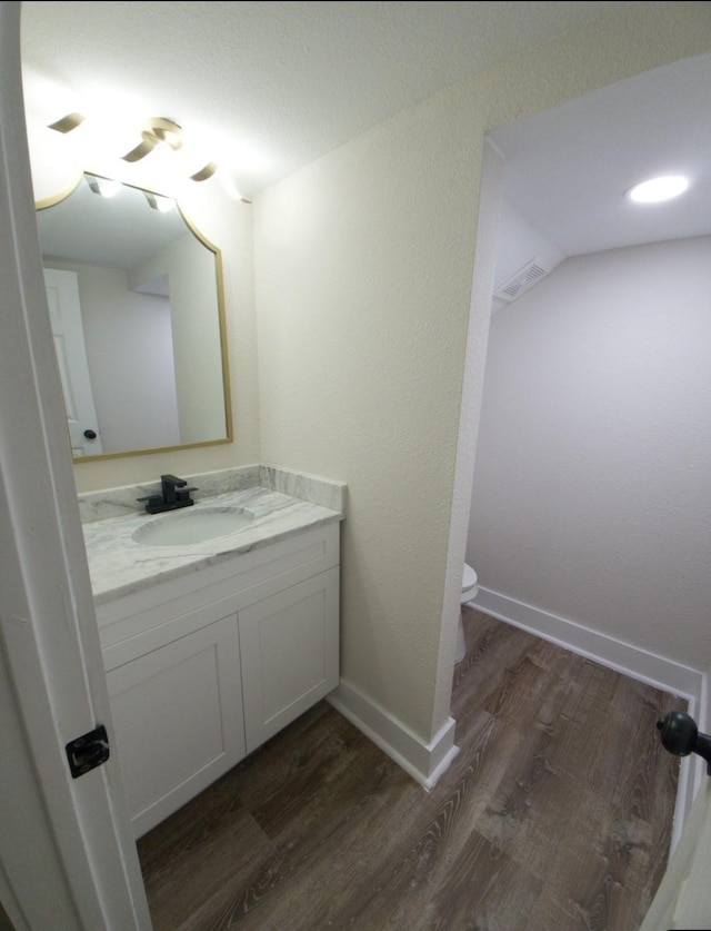 bathroom featuring hardwood / wood-style flooring, vanity, and toilet