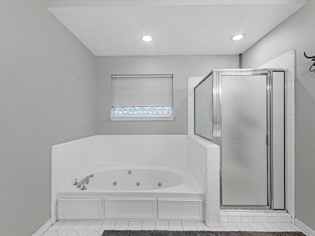 bathroom featuring separate shower and tub, tile patterned floors, and a textured ceiling