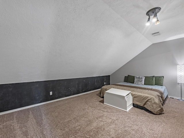 bedroom featuring vaulted ceiling, a textured ceiling, and carpet flooring