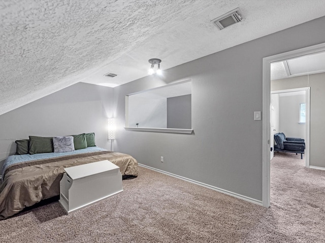 carpeted bedroom with a textured ceiling and vaulted ceiling