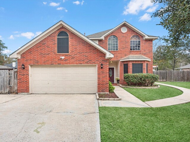 traditional home with concrete driveway, a front lawn, fence, and brick siding