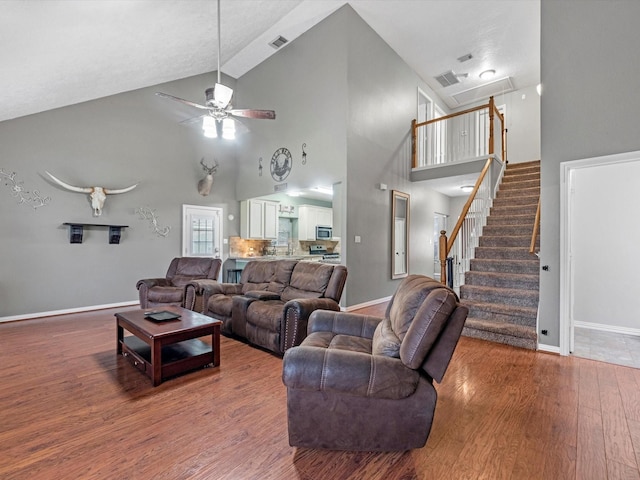 living room featuring high vaulted ceiling, ceiling fan, and wood-type flooring