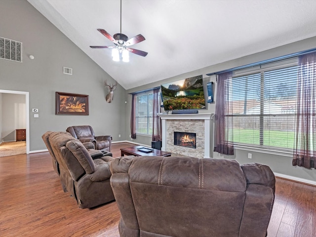 living room featuring ceiling fan, high vaulted ceiling, a fireplace, and hardwood / wood-style flooring