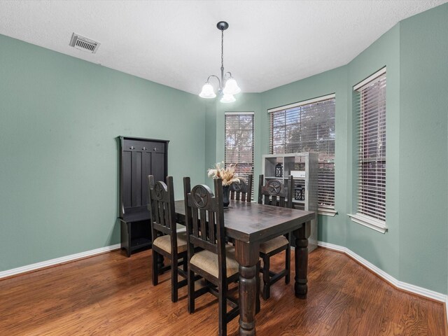 dining area featuring wood-type flooring and an inviting chandelier