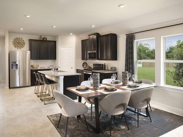 tiled dining room with sink and a wealth of natural light