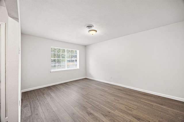 spare room with dark hardwood / wood-style flooring and a textured ceiling