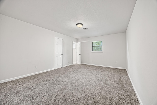 spare room featuring carpet and a textured ceiling