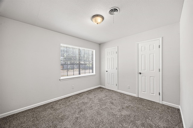 unfurnished bedroom featuring a textured ceiling and carpet floors