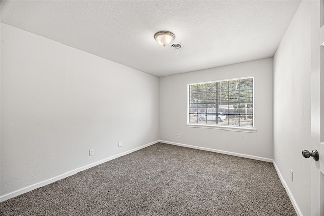 carpeted empty room with a textured ceiling