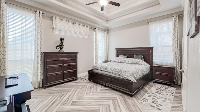 bedroom featuring light parquet floors, a raised ceiling, ceiling fan, and ornamental molding