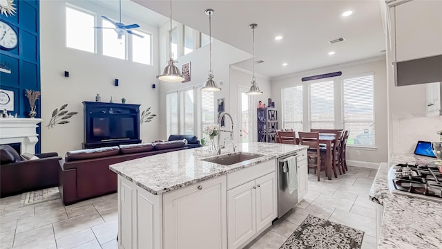 kitchen featuring white cabinetry, sink, light stone countertops, stainless steel dishwasher, and a kitchen island with sink