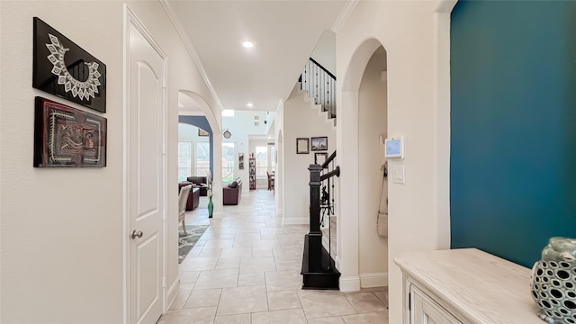 hall with light tile patterned floors and ornamental molding