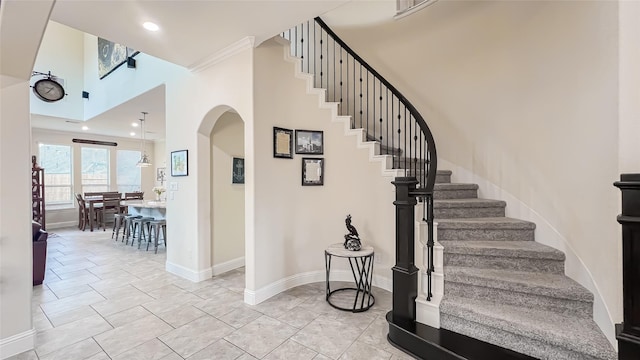 staircase featuring tile patterned floors and ornamental molding