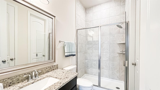 bathroom with vanity, an enclosed shower, and toilet