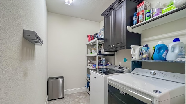 laundry room featuring washer and dryer, cabinets, and light tile patterned floors