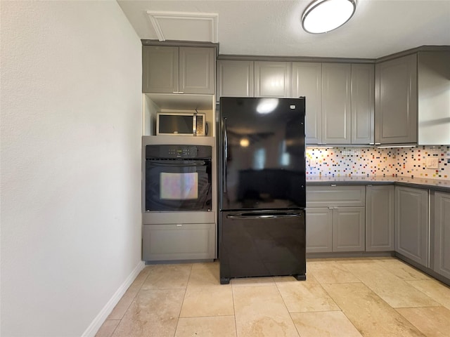 kitchen with black appliances, decorative backsplash, light tile patterned flooring, and gray cabinetry