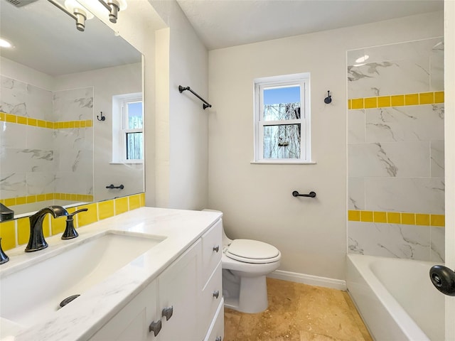 full bathroom with tiled shower / bath, vanity, and toilet