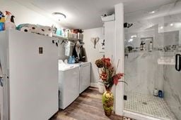 clothes washing area featuring washer and clothes dryer and hardwood / wood-style flooring