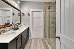 bathroom with vanity, an enclosed shower, and hardwood / wood-style flooring