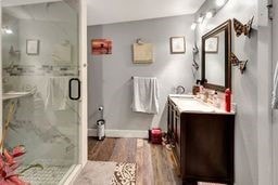 bathroom with wood-type flooring, vanity, and a shower with shower door