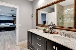 bathroom with tiled shower, vanity, and hardwood / wood-style flooring