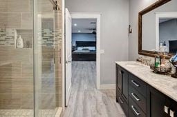 bathroom featuring vanity, wood-type flooring, and an enclosed shower