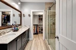 bathroom featuring hardwood / wood-style floors, vanity, and an enclosed shower