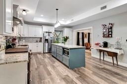 kitchen featuring a center island, white cabinets, a raised ceiling, light hardwood / wood-style flooring, and appliances with stainless steel finishes