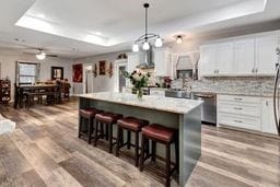 kitchen featuring white cabinets, a center island, hardwood / wood-style floors, and a tray ceiling