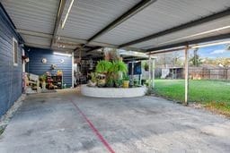 garage featuring a lawn and a carport