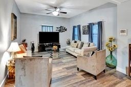 living room featuring ceiling fan, hardwood / wood-style floors, and plenty of natural light