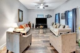 living room featuring ceiling fan and light hardwood / wood-style floors