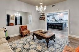 living room featuring wood-type flooring and an inviting chandelier