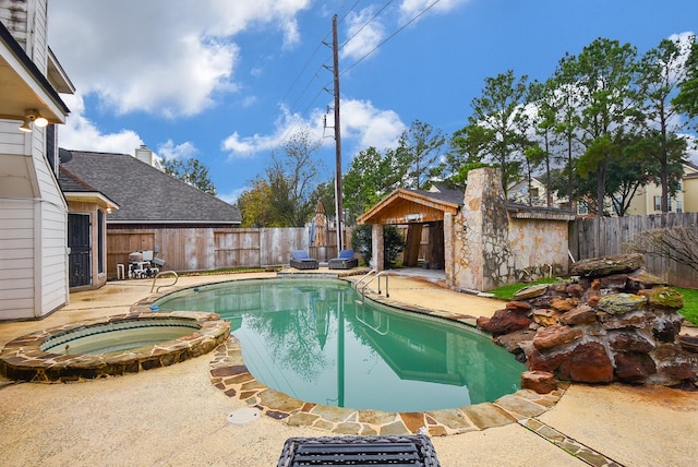 view of swimming pool with an in ground hot tub