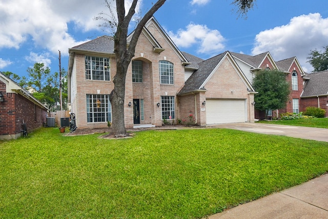 view of front of house featuring a garage, a front lawn, and central air condition unit