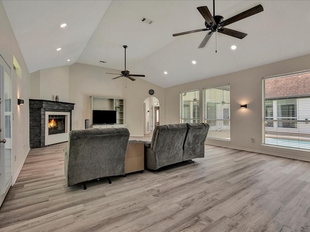 living room with ceiling fan, light hardwood / wood-style flooring, and lofted ceiling