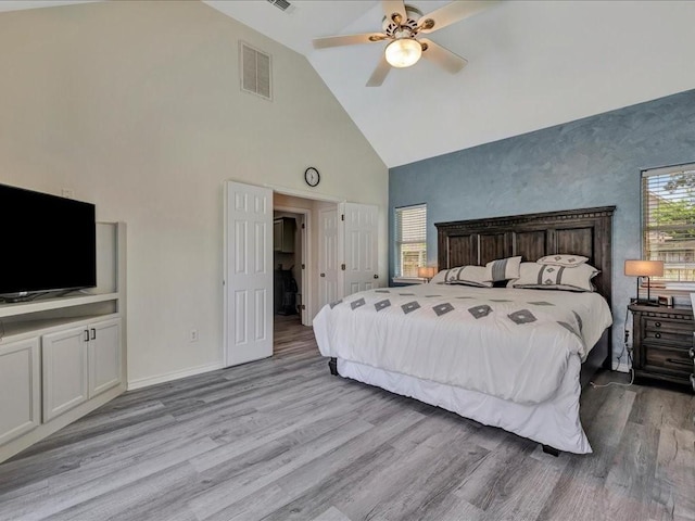 bedroom featuring ceiling fan, light hardwood / wood-style flooring, and high vaulted ceiling