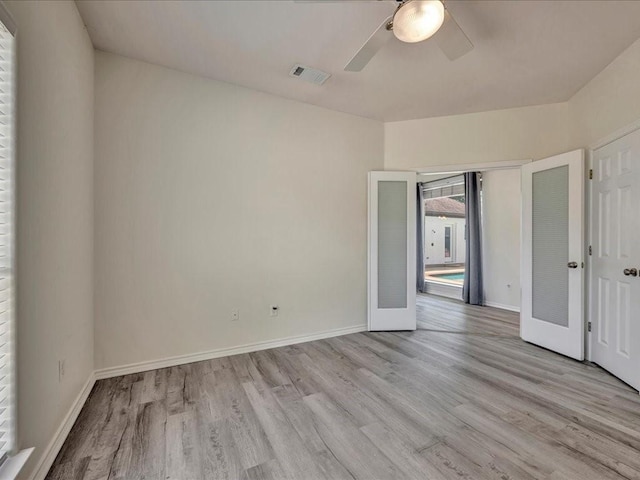 unfurnished bedroom featuring ceiling fan, french doors, and light hardwood / wood-style floors