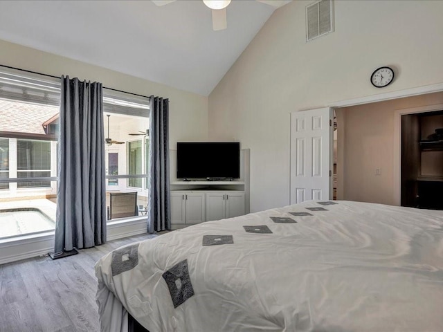 bedroom featuring ceiling fan, vaulted ceiling, light hardwood / wood-style flooring, and multiple windows