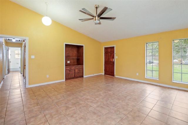 tiled empty room with built in shelves, ceiling fan, and vaulted ceiling