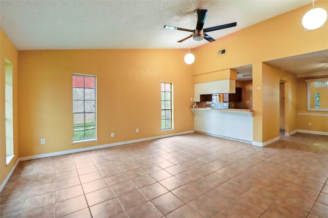 unfurnished living room with ceiling fan, light tile patterned floors, a textured ceiling, and lofted ceiling