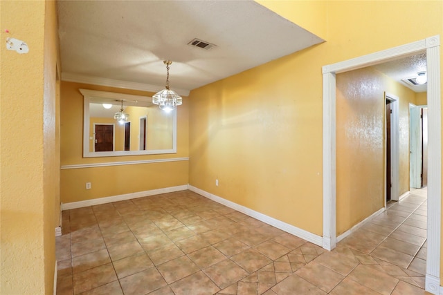 tiled spare room with ornamental molding, a textured ceiling, and a notable chandelier