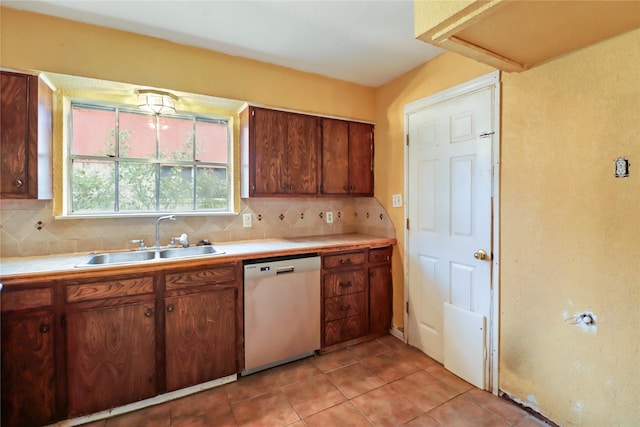 kitchen featuring backsplash, dishwasher, light tile patterned floors, and sink