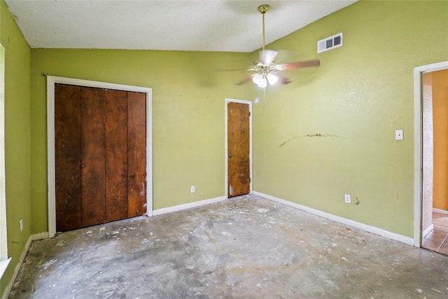 unfurnished bedroom with ceiling fan, concrete floors, lofted ceiling, and a closet