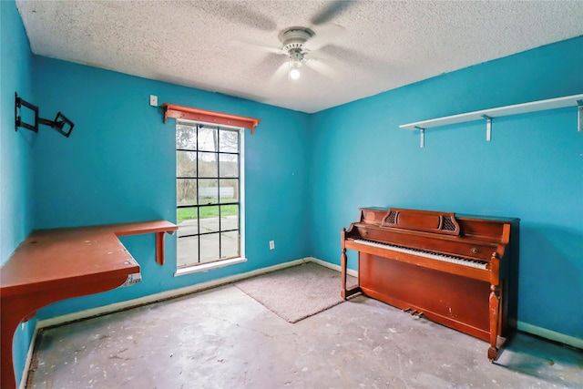 misc room with ceiling fan and a textured ceiling