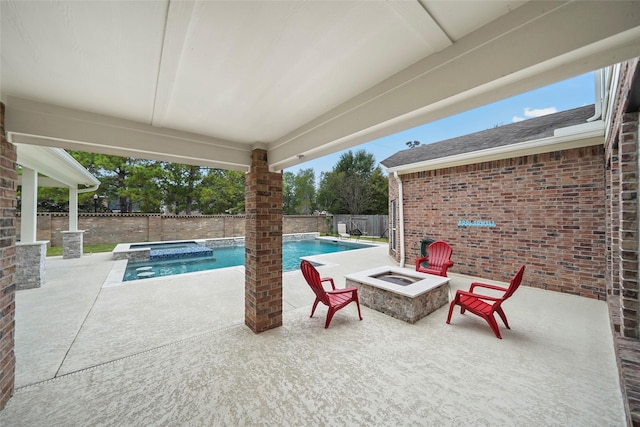 view of pool with an in ground hot tub, a patio area, and an outdoor fire pit