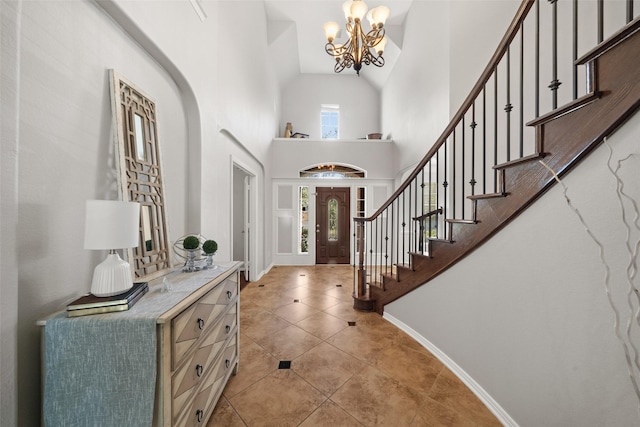 entryway with a chandelier, a high ceiling, and light tile patterned flooring