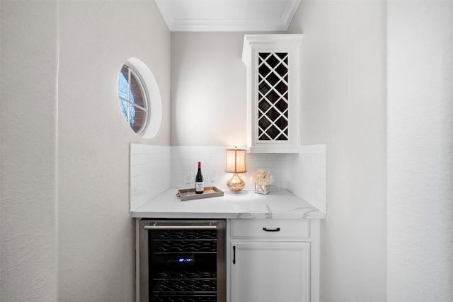 bar featuring wine cooler, ornamental molding, decorative backsplash, and white cabinets