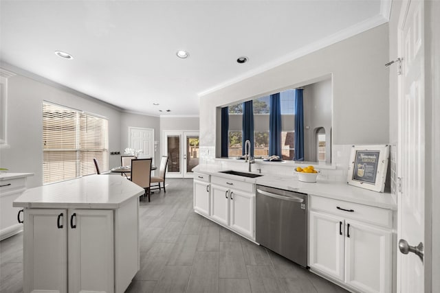 kitchen featuring sink, tasteful backsplash, a center island, dishwasher, and white cabinets